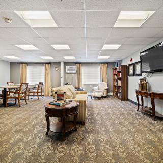 A spacious and well-lit living room with comfortable seating, a large television, and stylish decor.