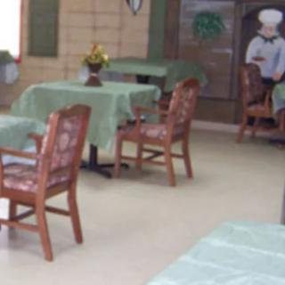 An empty restaurant dining area with tables and chairs neatly arranged.