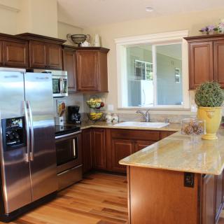A modern kitchen with wood cabinets and stainless steel appliances.