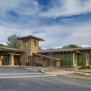 A modern building featuring stone architecture under a blue sky.