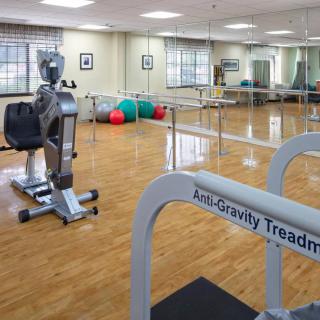 A gym equipped with an anti-gravity treadmill and various exercise machines, ideal for rehabilitation and therapy.