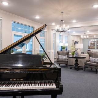 A modern living room featuring a grand piano and elegant furnishings.