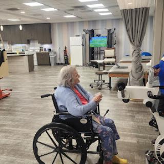 A senior individual in a wheelchair participates in activities at a rehabilitation center.