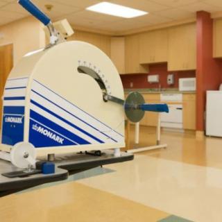 A specialized exercise machine in a gym setting designed for rehabilitation purposes.