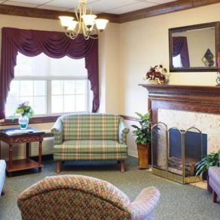 A cozy living room with a fireplace, sofa, and chairs.