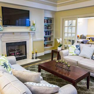 A cozy living room with a fireplace, sofas, and a modern coffee table.