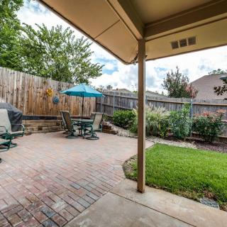 A cozy backyard patio with outdoor furniture and a green lawn.