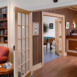 A cozy interior view featuring a living room with a library, French doors leading to a room with a pool table.