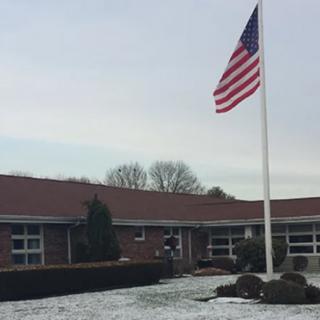 A building with the American flag flying on a snowy day.