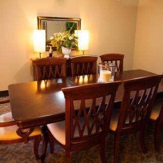 A cozy and elegant dining room setup featuring a wooden table and chairs, complemented by soft lighting and decorative elements.