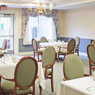 An elegant dining room setup with formally arranged tables and chairs.