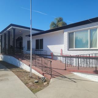 A modern residential house with a ramp for accessibility under a clear blue sky.