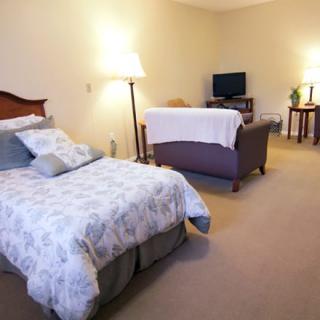 A cozy bedroom with a bed, sofa, and television creating a comfortable living space.