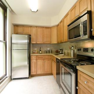 A modern kitchen featuring stainless steel appliances and wooden cabinets.