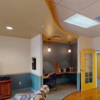 A modern office interior with a workspace, featuring colorful decor and lighting.