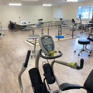 A spacious physical therapy gym equipped with various exercise equipment.