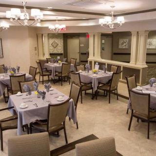 An elegant dining room setup with neatly arranged tables and chairs under chandeliers.