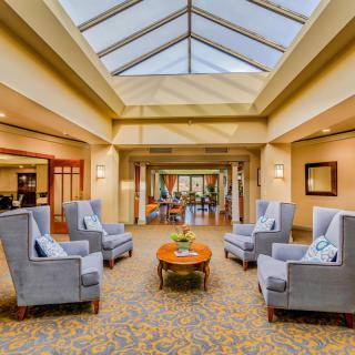 A modern lobby with comfortable armchairs and a skylight ceiling.