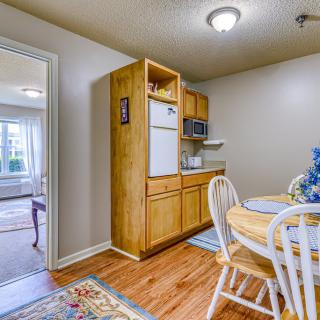 A cozy kitchen with wooden cabinets and a small dining area featuring a round table and chairs.