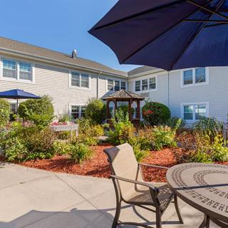 A sunny courtyard with seating and a landscaped garden area.