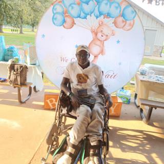 A joyful moment captured during an outdoor celebration, showcasing a person in a wheelchair enjoying the festivities.