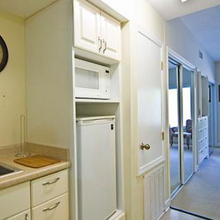 A modern kitchen setup with built-in appliances next to a hallway.