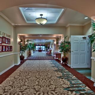 A well-decorated hallway with a patterned carpet and ceiling lighting.