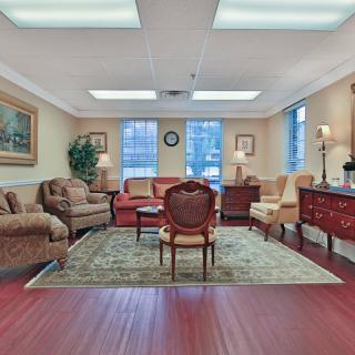 A well-furnished living room with a variety of seating options arranged around a central rug.