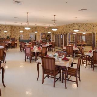 An elegant dining area featuring neatly arranged tables and chairs with tasteful lighting.