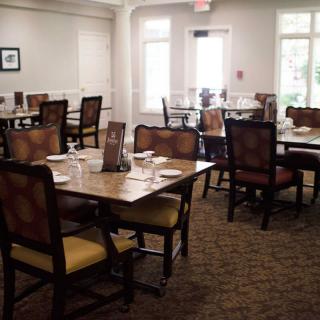 An empty dining room with neatly arranged tables and chairs.