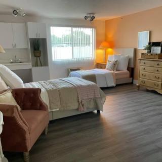A spacious bedroom with two beds, a dresser, and modern decor.