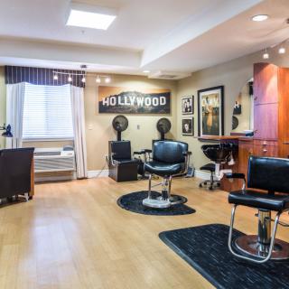 A modern hair salon with a Hollywood theme, featuring classic barber chairs and stylish interior decor.