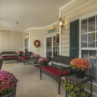 A cozy porch with comfortable seating and vibrant flower decorations.