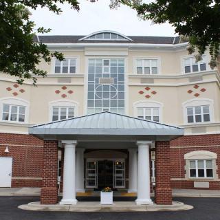 A multi-story residential building with a columned entrance.