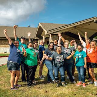 A joyful gathering of a diverse group celebrating together outdoors.