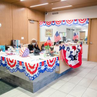 A festive office space decorated with patriotic themes, featuring flags and red, white, and blue elements.