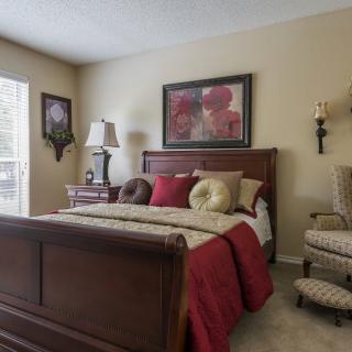 A cozy bedroom with a wooden bed and warm decor.