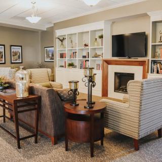 A cozy living room featuring comfortable seating, a fireplace, and built-in bookshelves.