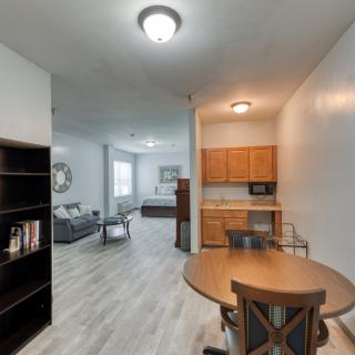 A modern apartment interior featuring a living room, kitchen, and dining area with stylish furniture.