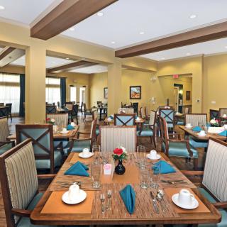 A well-decorated dining room with neatly arranged tables and chairs.