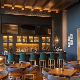 A stylish and modern bar interior with comfortable seating and warm lighting.