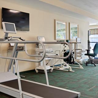 A modern fitness area featuring a treadmill and other exercise equipment.