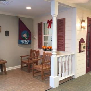 A cozy indoor porch area featuring wooden chairs and homey decorations.