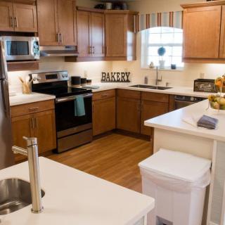 A modern kitchen with wood cabinets, stainless steel appliances, and a kitchen island.