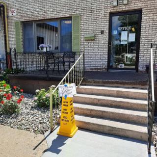 A welcoming entrance with a flower garden and safety signage.