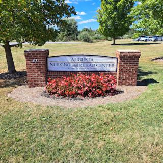 A sign marking a local institution, surrounded by well-maintained grass and flower beds.