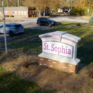 A welcoming sign for St. Sophia located in a community setting.