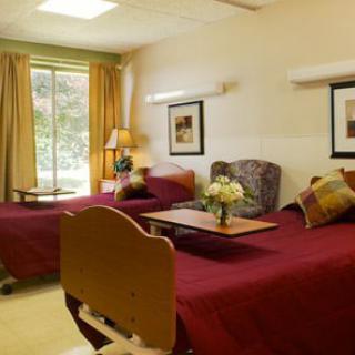 A hospital room with two twin beds and a window with curtains.