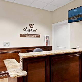 A reception area with a wooden front desk and signage on the wall.