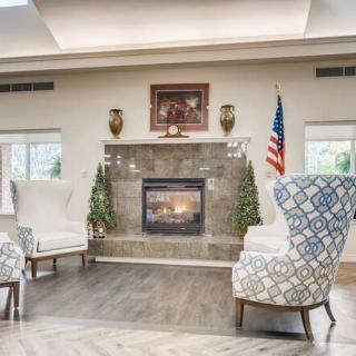 A cozy seating area featuring a fireplace, decorative chairs, and a patriotic theme with an American flag.
